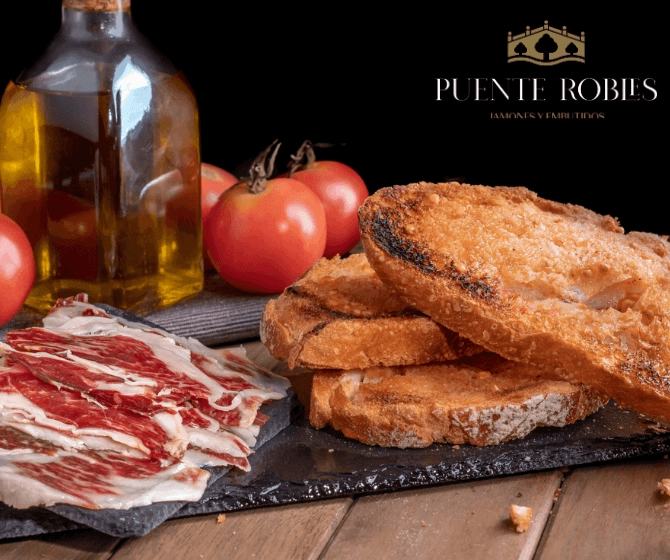 bread toasts with thin slices of Iberian ham, olive oil and tomato