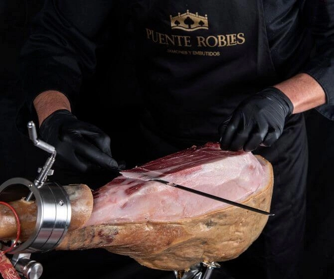 Master ham cutter cutting an Iberian ham Puente Robles